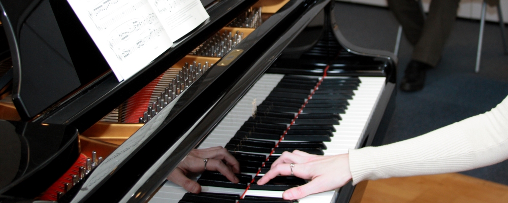A pianist playing a grand piano from sheet music