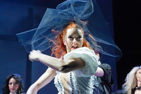 A musical theatre performer mid-number in costume