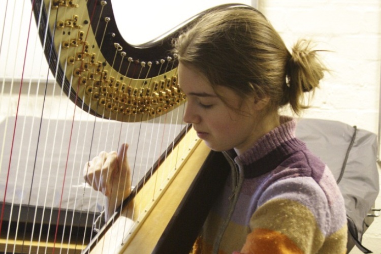 A student playing the harp